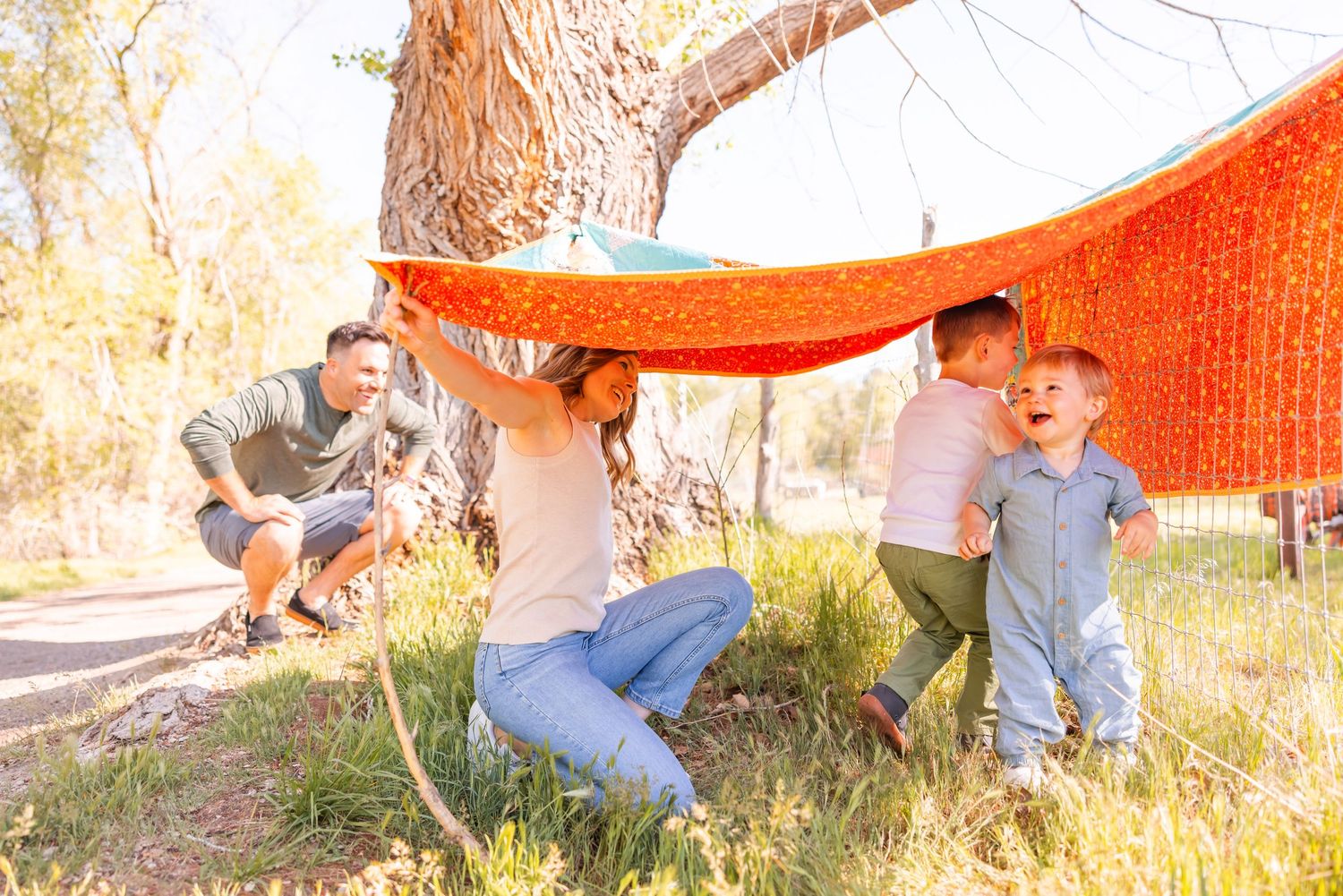 salt lake city candid family photographer, toddlers and family building a blanket fort under a tree