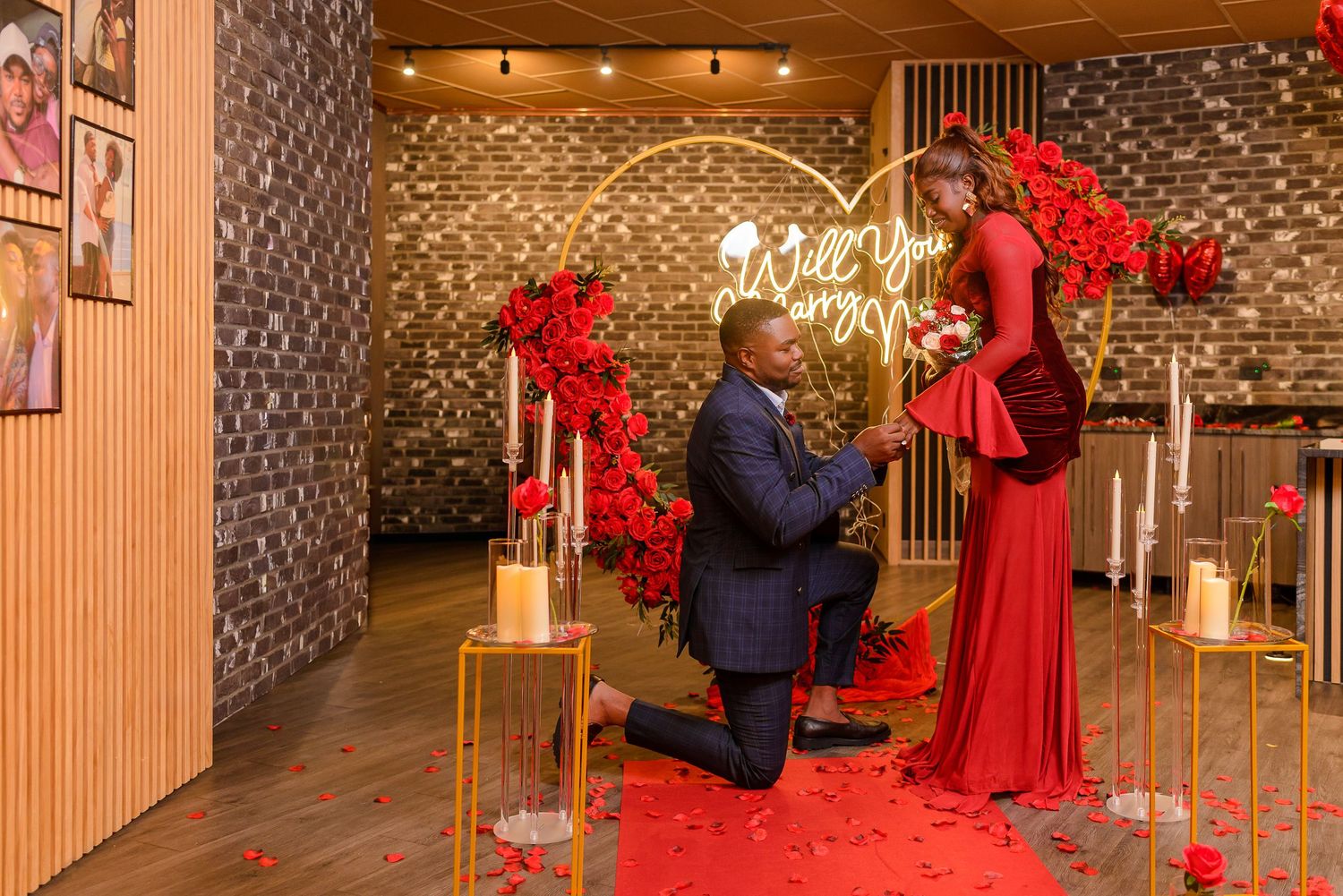 Couple in vibrant Nigerian traditional wedding attire, man in white agbada, woman in red gele and gown, posing on steps.