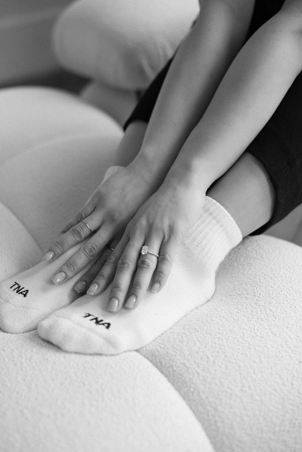 Close-up shots of hands gently touching white textured surface.