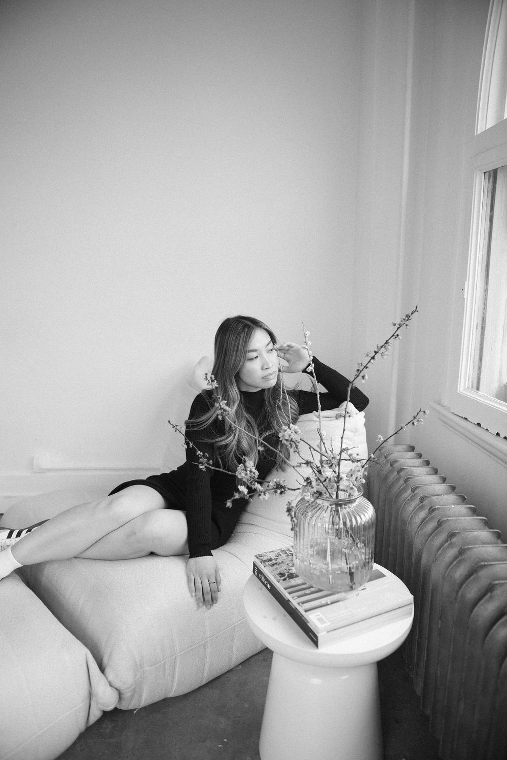 Relaxed lifestyle photo series with person reclining near decorative flowers on side table.