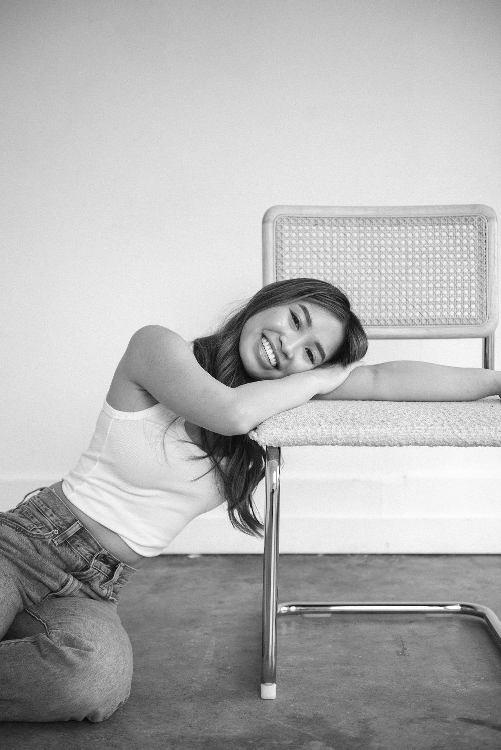 Black and white portrait series showing relaxed poses on retro-style furniture.