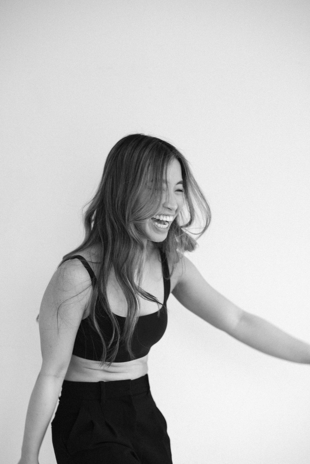 Candid expressions captured in black tank top against white background.