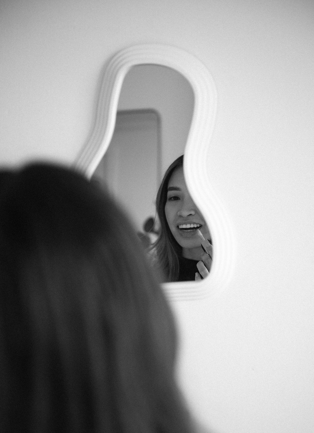 Reflective portrait series showing laughter and expressions in a decorative mirror.