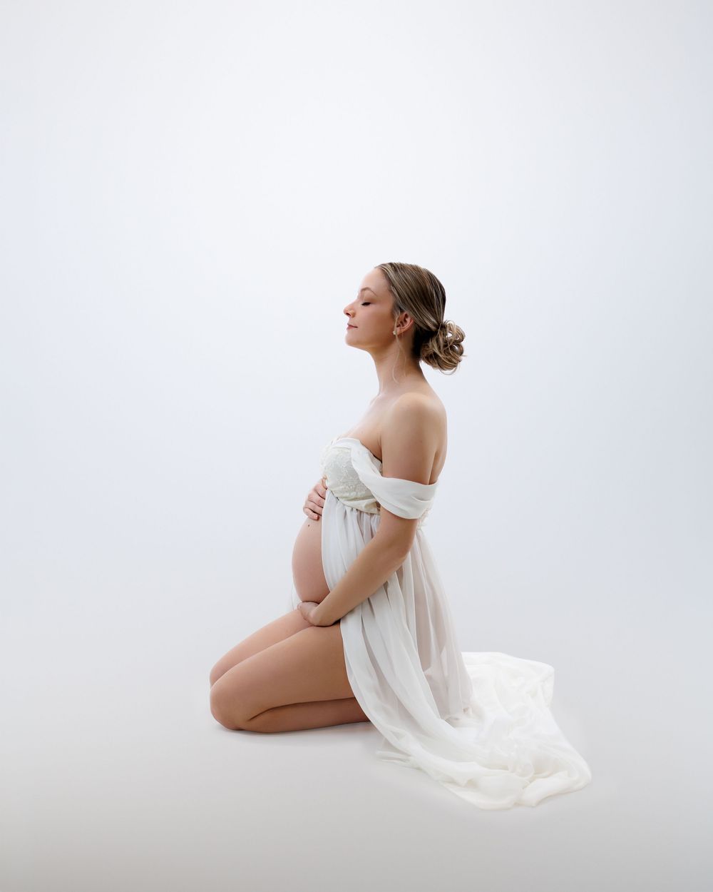 A figure in white fabric poses gracefully against a bright background in a minimalist artistic photo series.