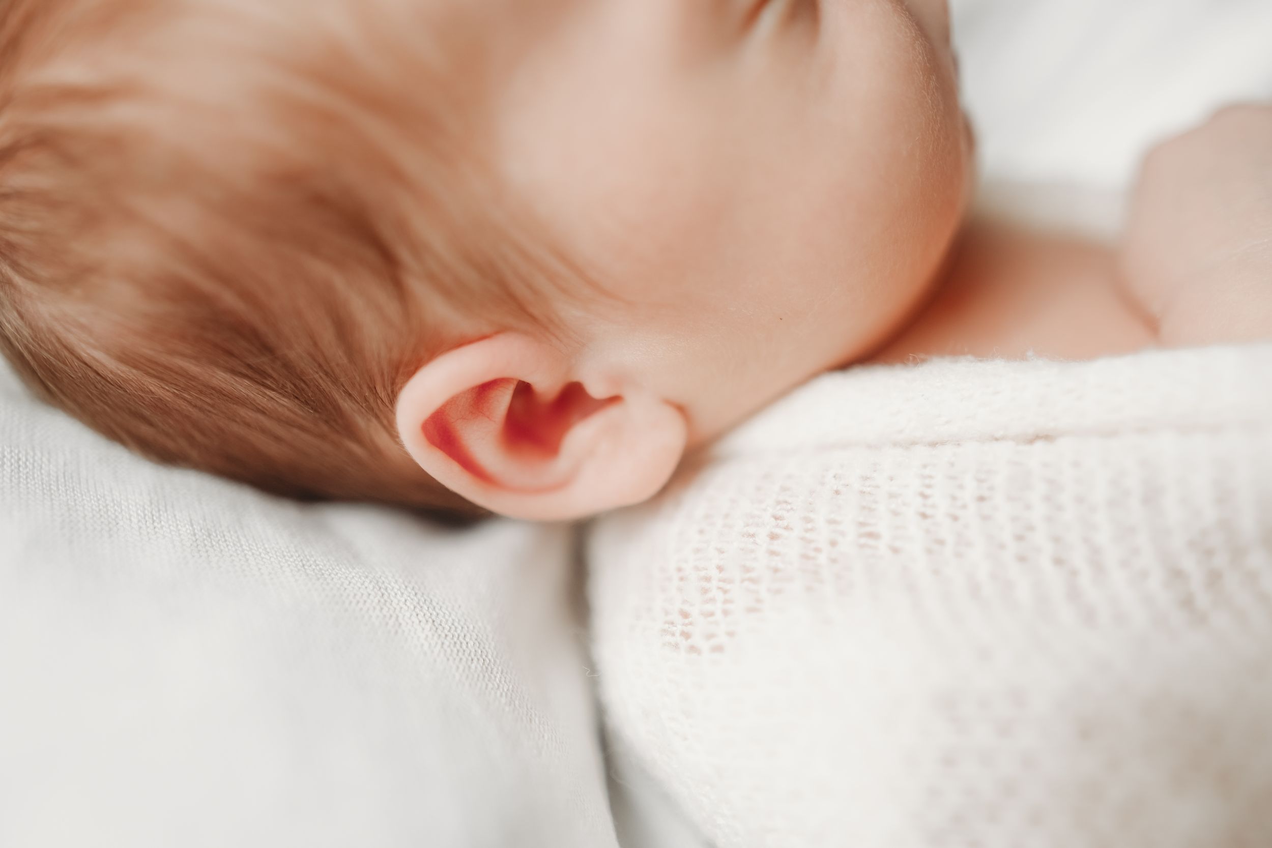 Close-up of white knitted blanket texture in soft lighting.
