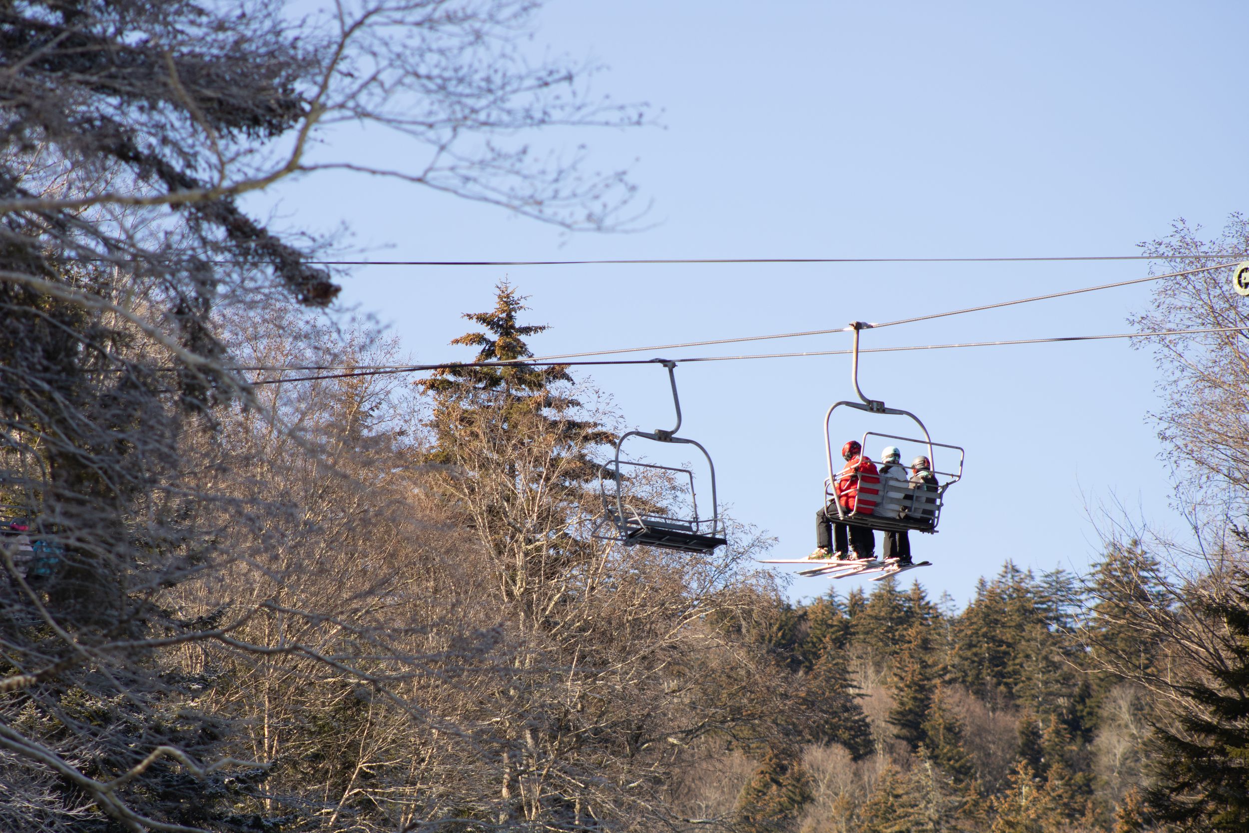 mountain Ski resort at sunset in winter with skiiers on the lift
