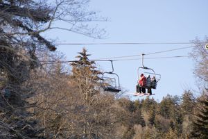 mountain Ski resort at sunset in winter with skiiers on the lift