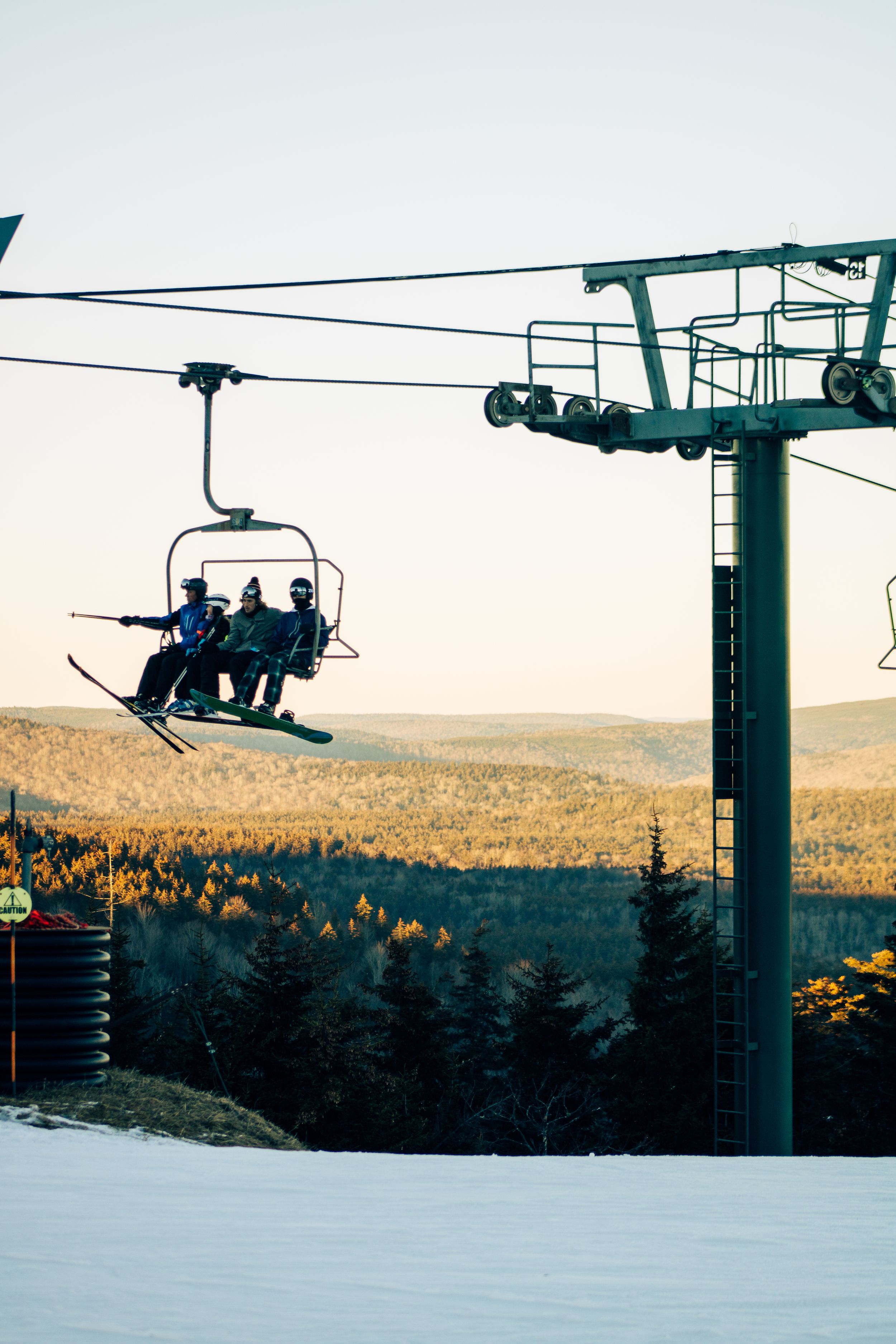mountain Ski resort at sunset in winter with skiiers on the lift