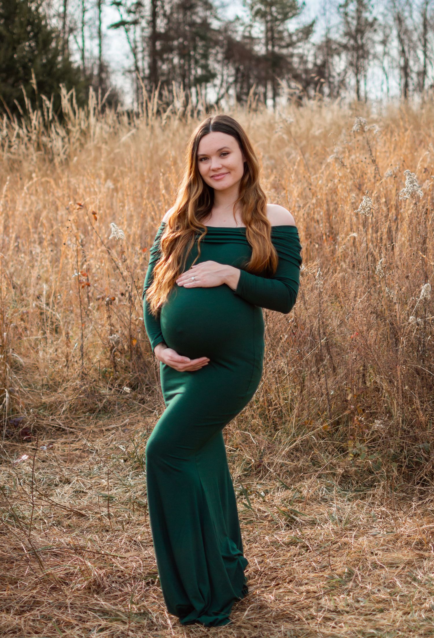 lady posed for maternity session in a grass field