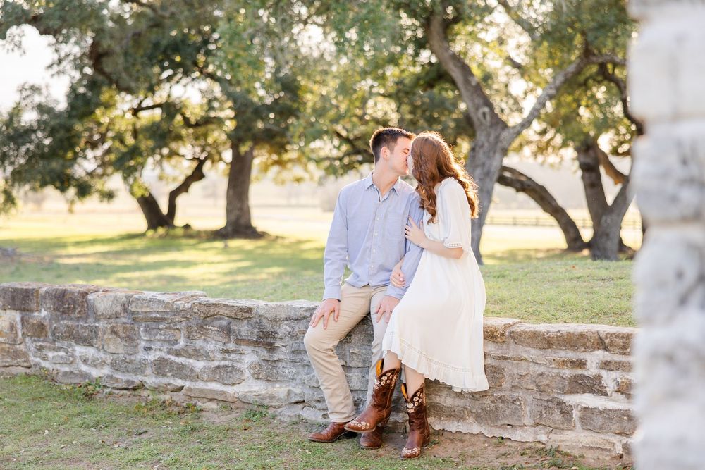 A couple shares an intimate moment while sitting on stone steps outdoors.