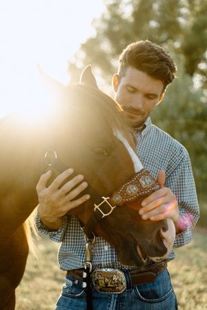 Creative travel portrait in McAlester Oklahoma, man with horse, dreamy light flares, and vintage grain.