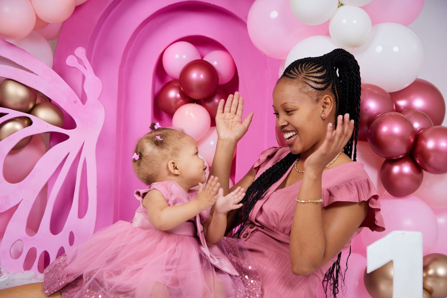 Pink balloon and butterfly themed birthday celebration photoshoot.