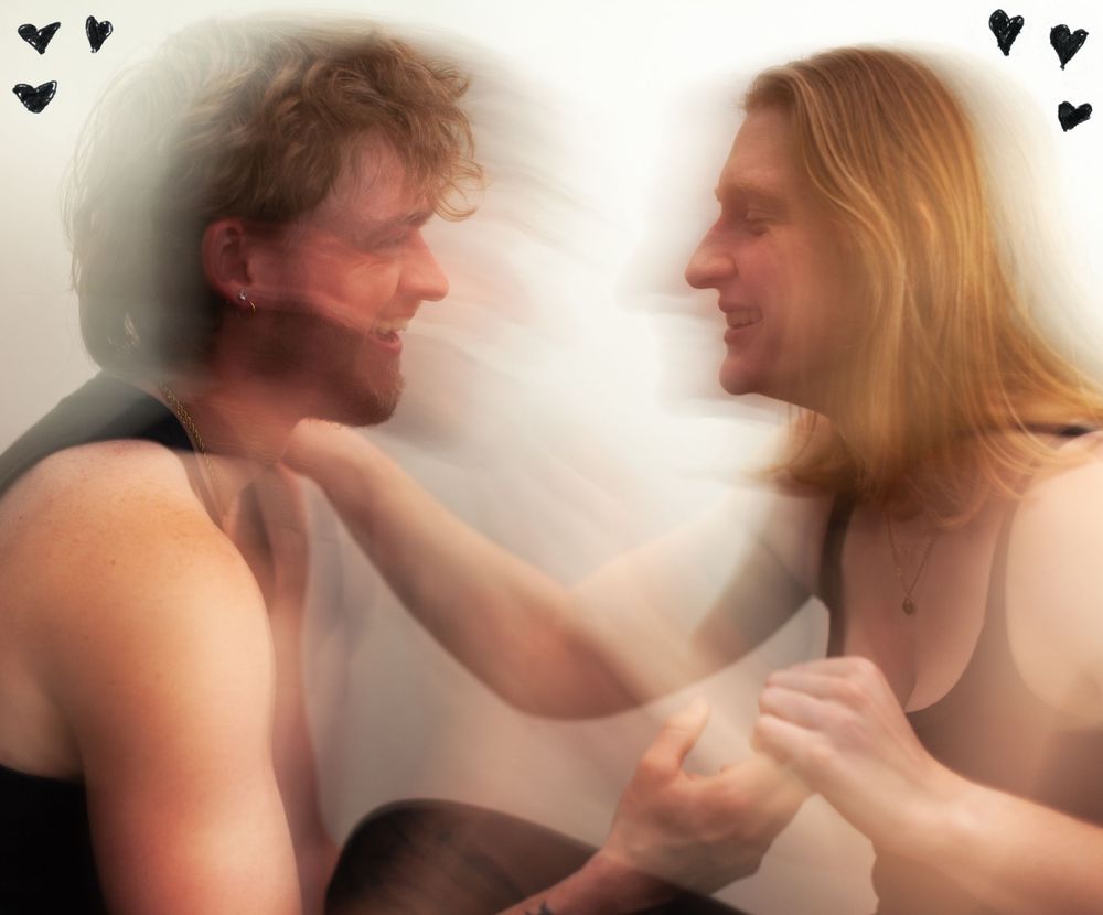 A man and a woman laughing together with hearts in the corners