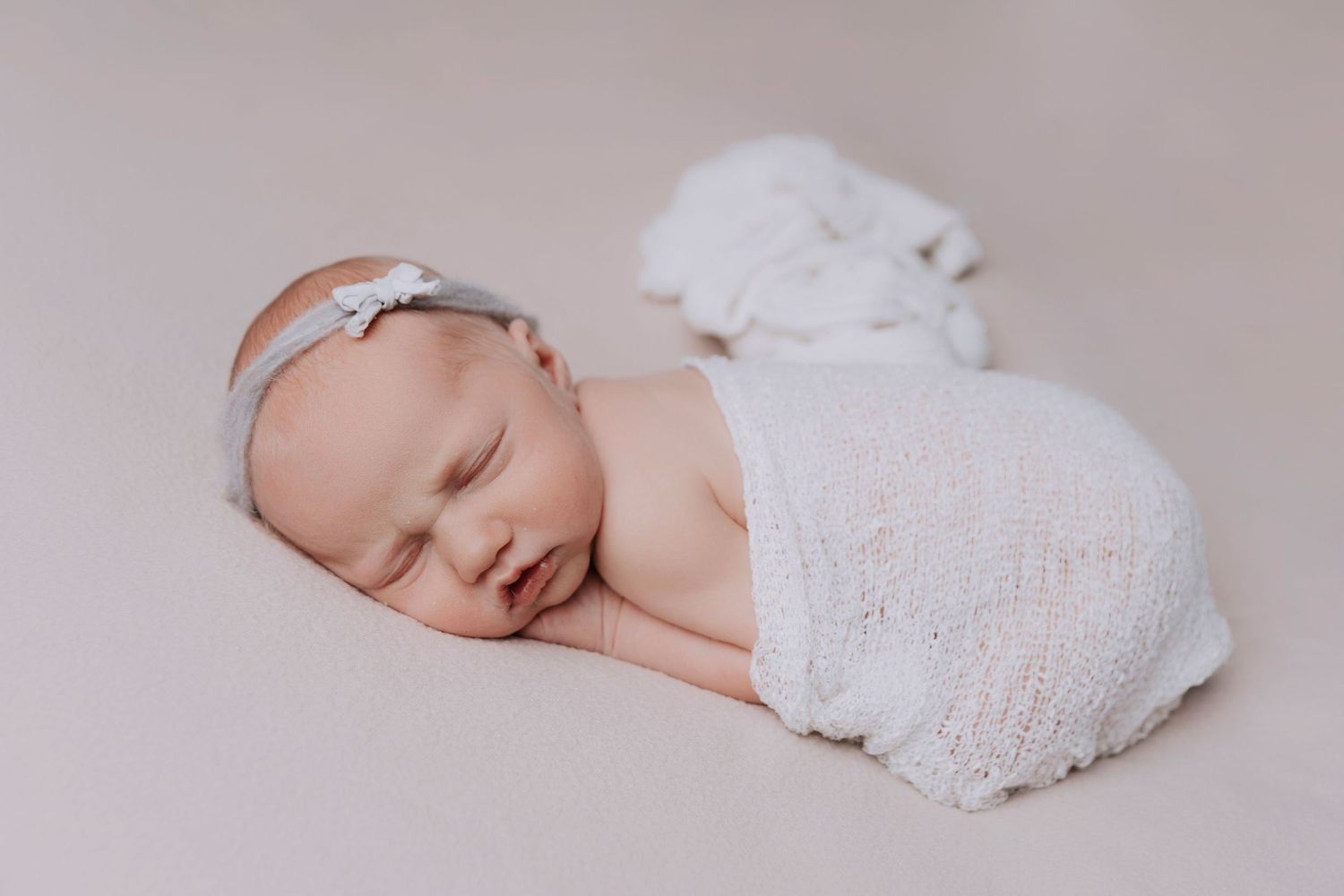 Delicate white floral and lace decorative elements arranged in a horizontal row against a light neutral background.