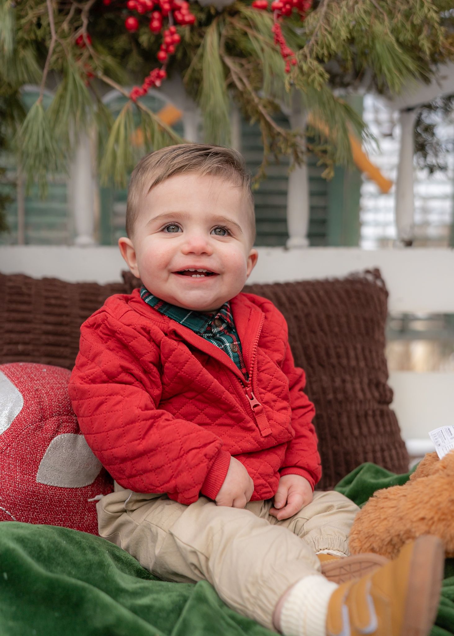 Cheerful holiday portrait featuring bright red jacket and festive Christmas decorations.