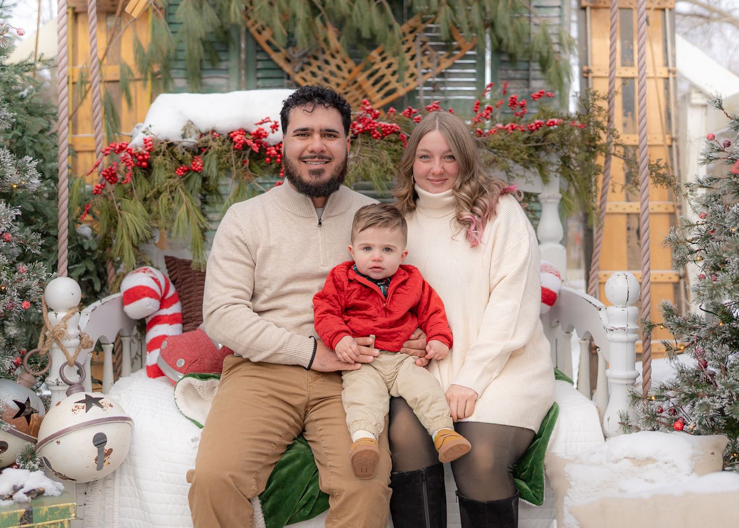 Family holiday portraits with Christmas decorations and greenery in the background.