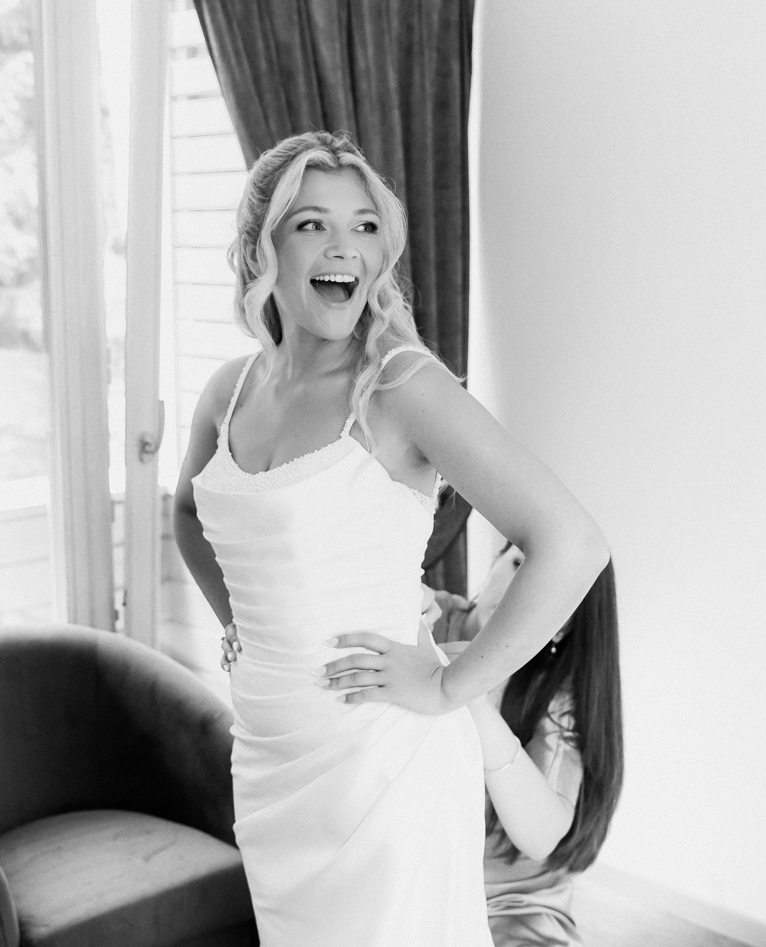 A series of black and white candid photos showing someone in a white dress dancing and laughing joyfully.