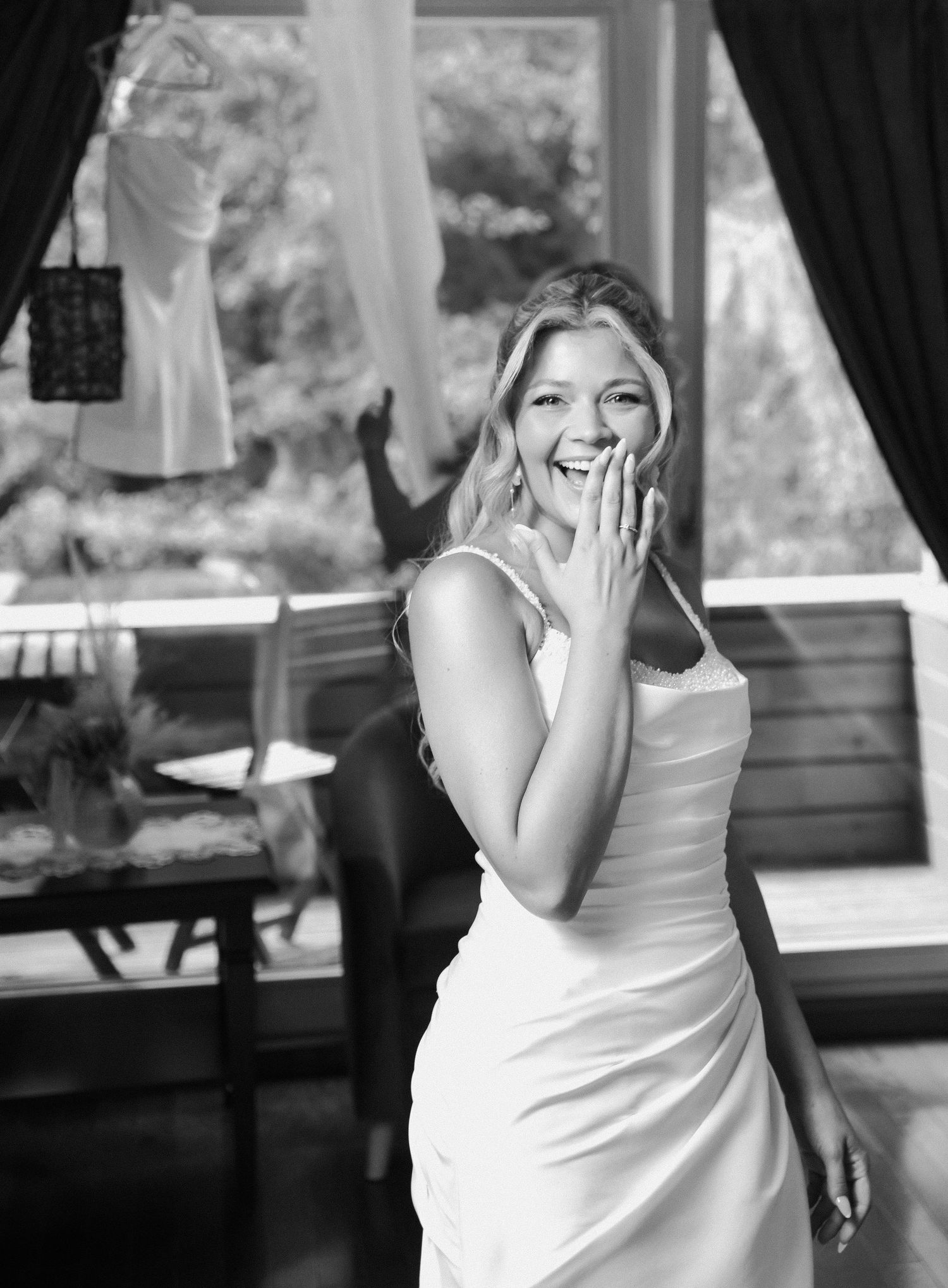 A sequence of five black and white photos showing a person in a white dress laughing and posing playfully.