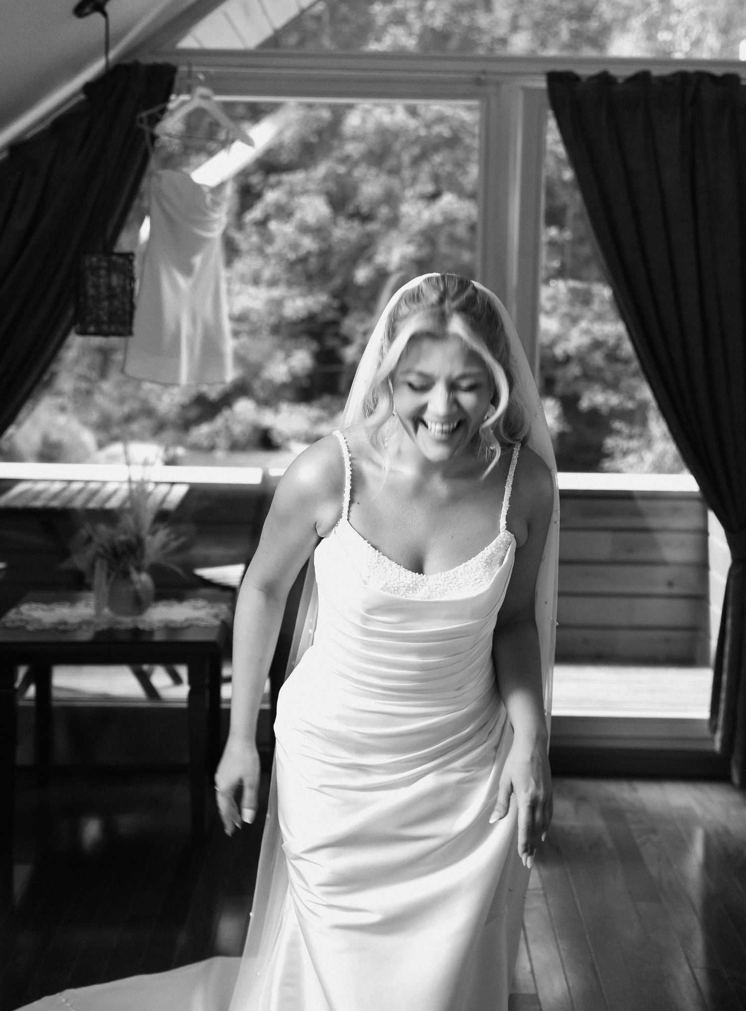 Series of black and white photos showing a person in a white tank top dancing joyfully indoors.