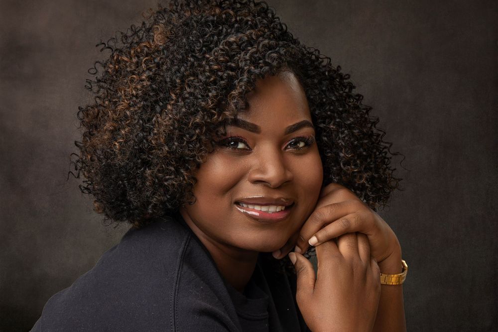 Studio portrait series with natural curly hair against dark dramatic background.