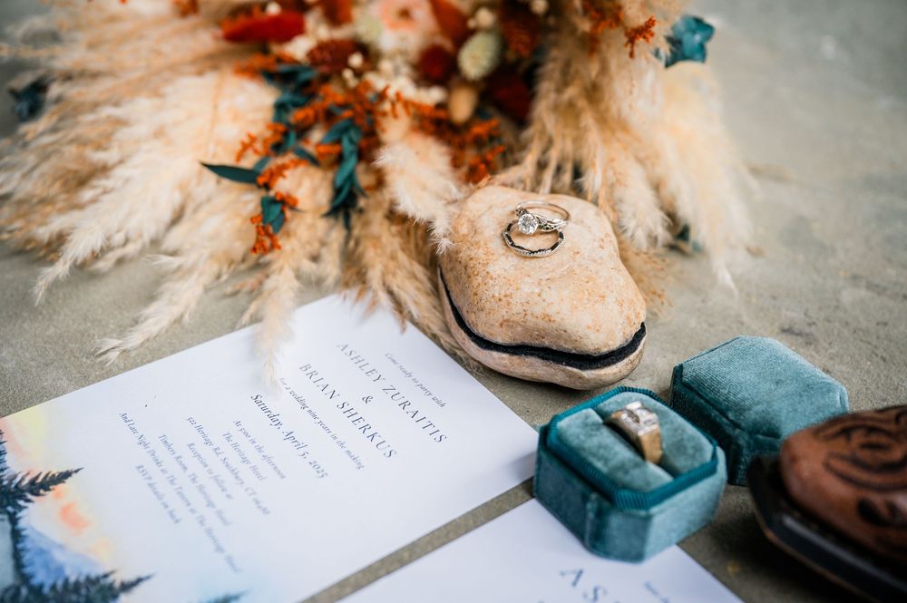 Wedding invitations and decorative details featuring pampas grass and rustic boots.