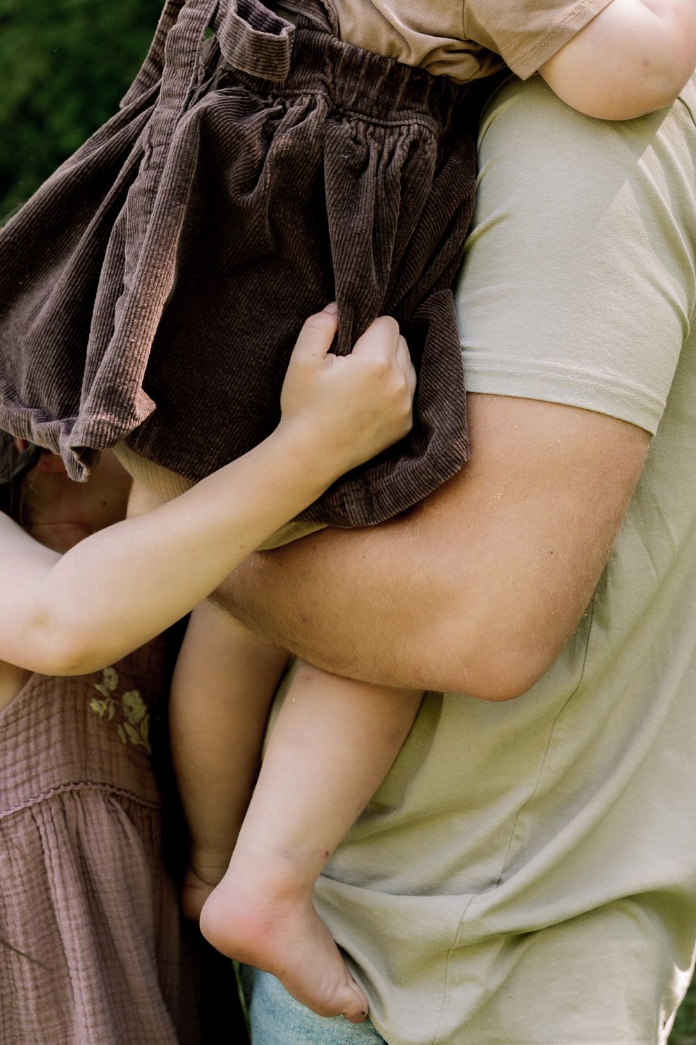 A series of close-up shots showing someone holding a small baby wearing brown pants against a light background.