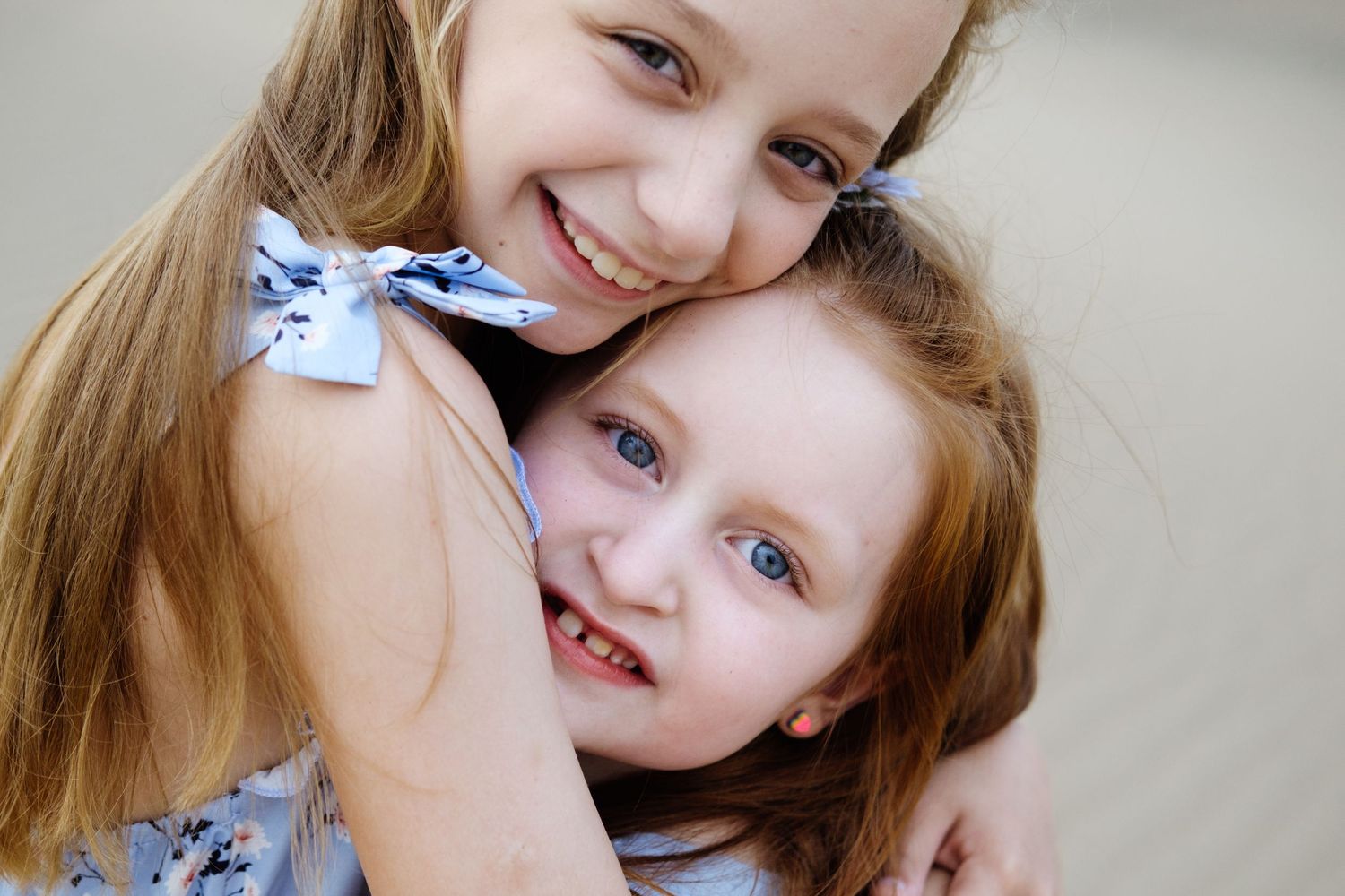 Two young cousins hugging and smiling during a candid children’s photography session