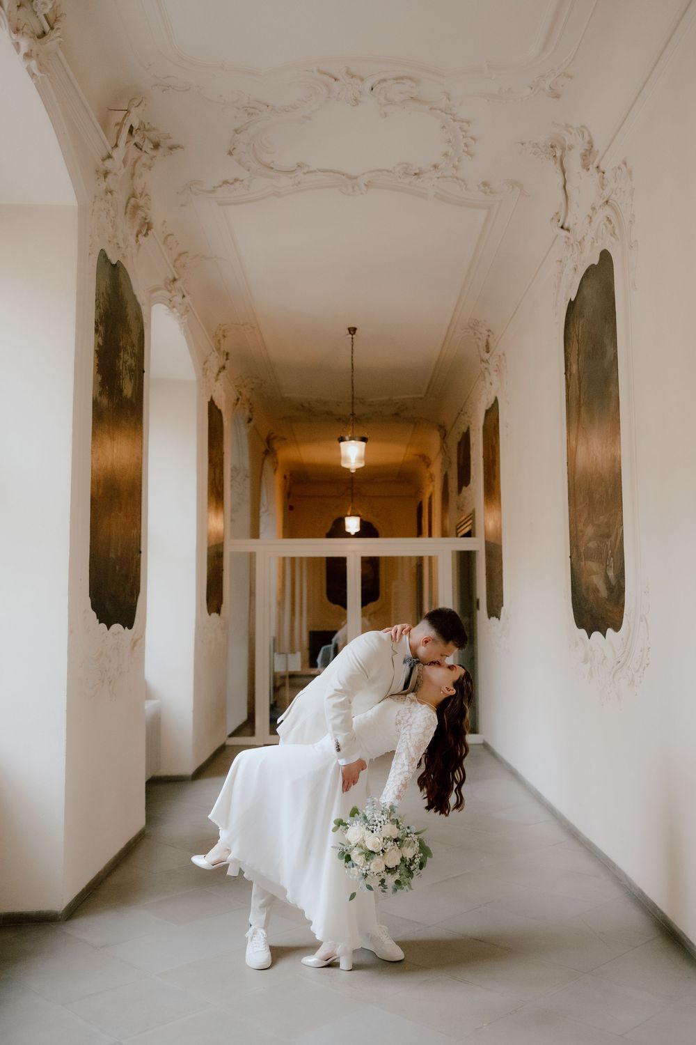 A series of romantic wedding photos captured in a grand white hallway with ornate ceiling details.