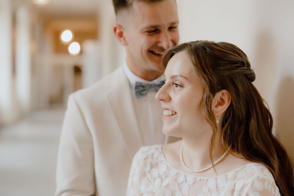 A couple shares a joyful moment together during their wedding celebration in an elegant indoor venue.