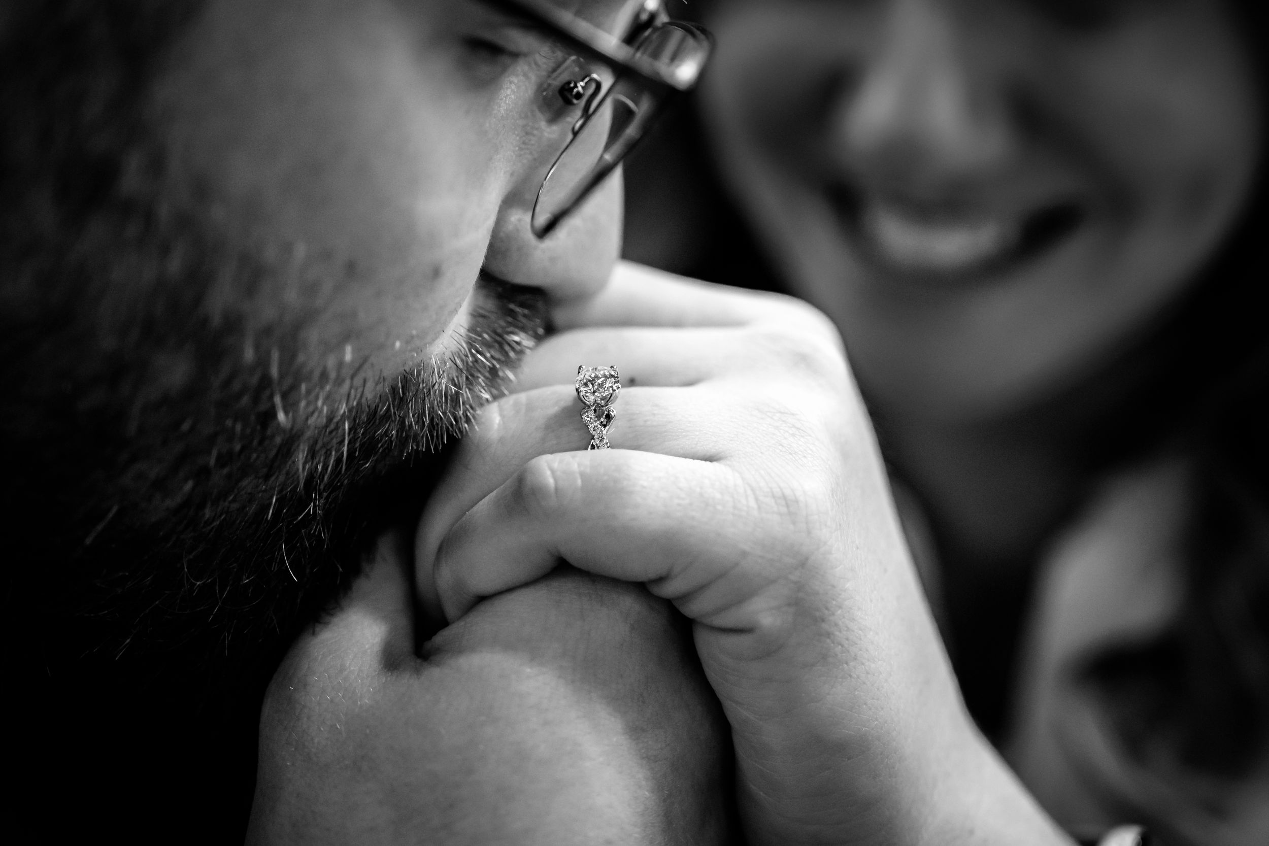A romantic couple shares a close moment in black and white photography.