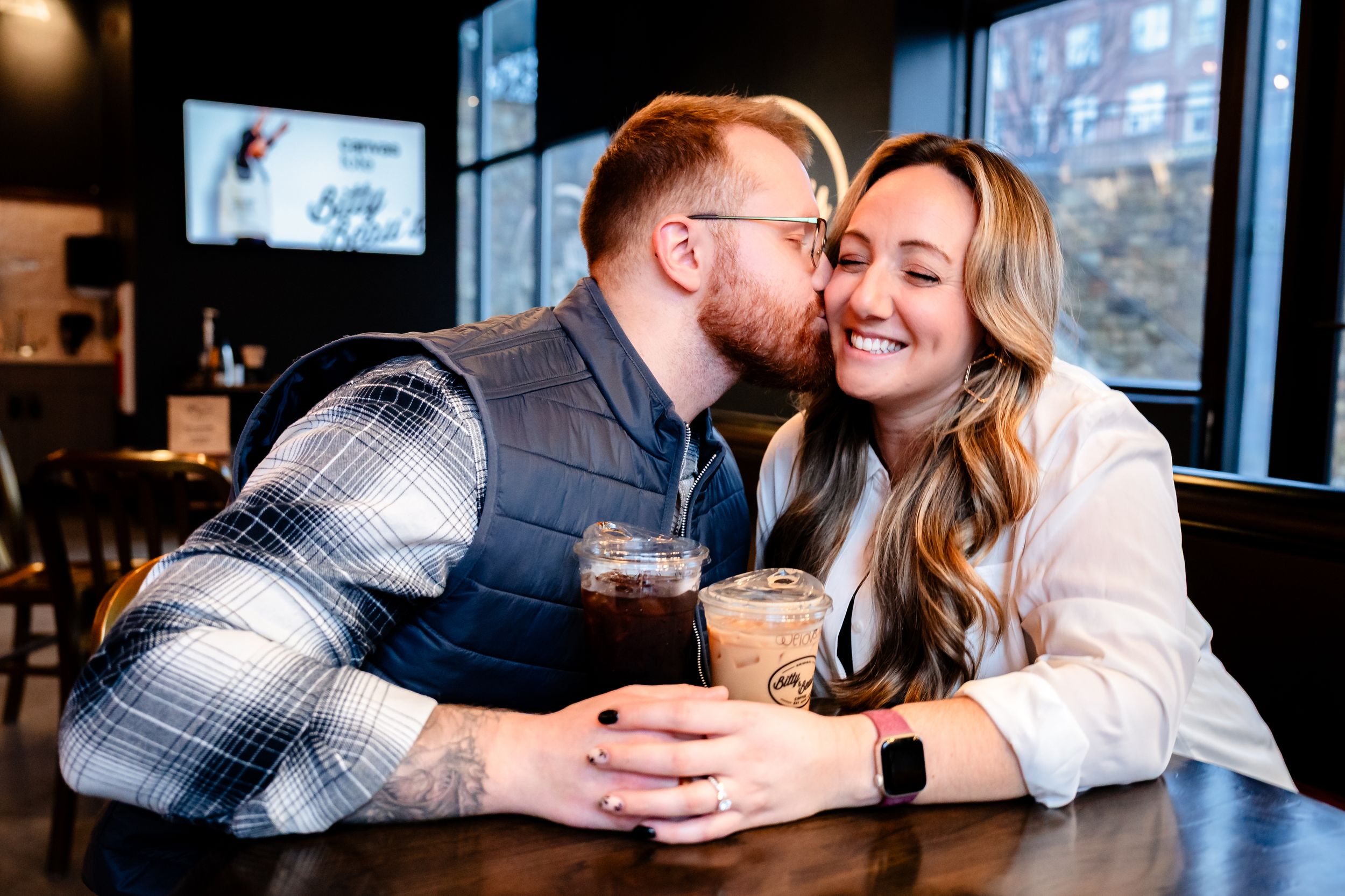 Couple sharing intimate moments at a bar counter while enjoying drinks together.