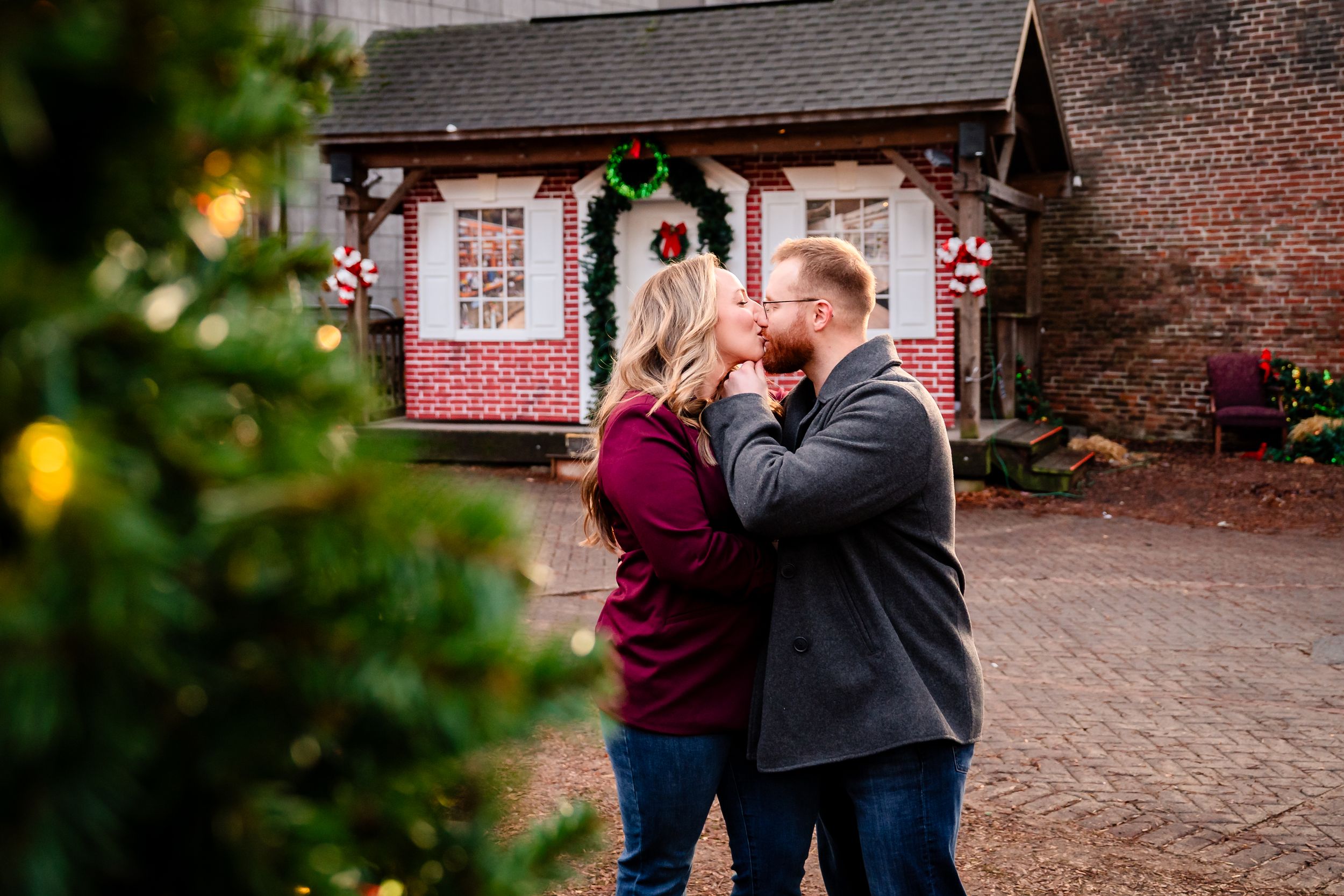 A romantic couple shares a tender moment on a brick paved walkway during an autumn engagement photoshoot.