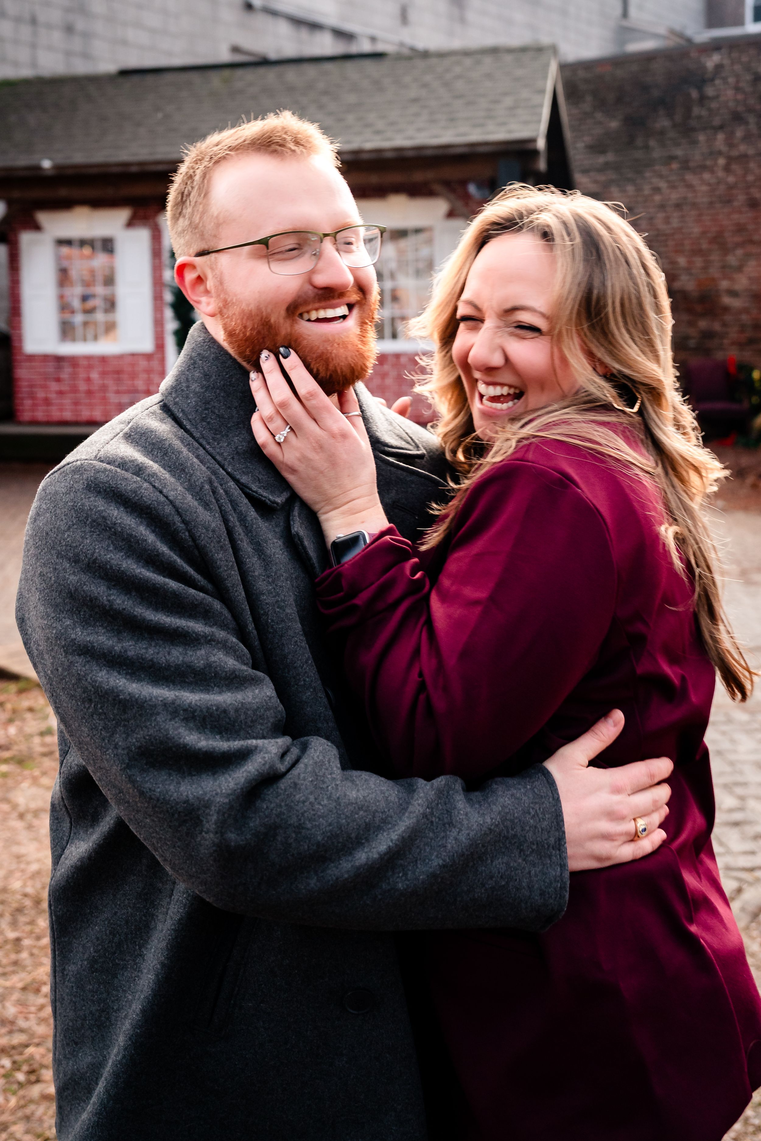 A couple in burgundy and gray outfits share joyful laughter and embrace in a series of candid outdoor photos.