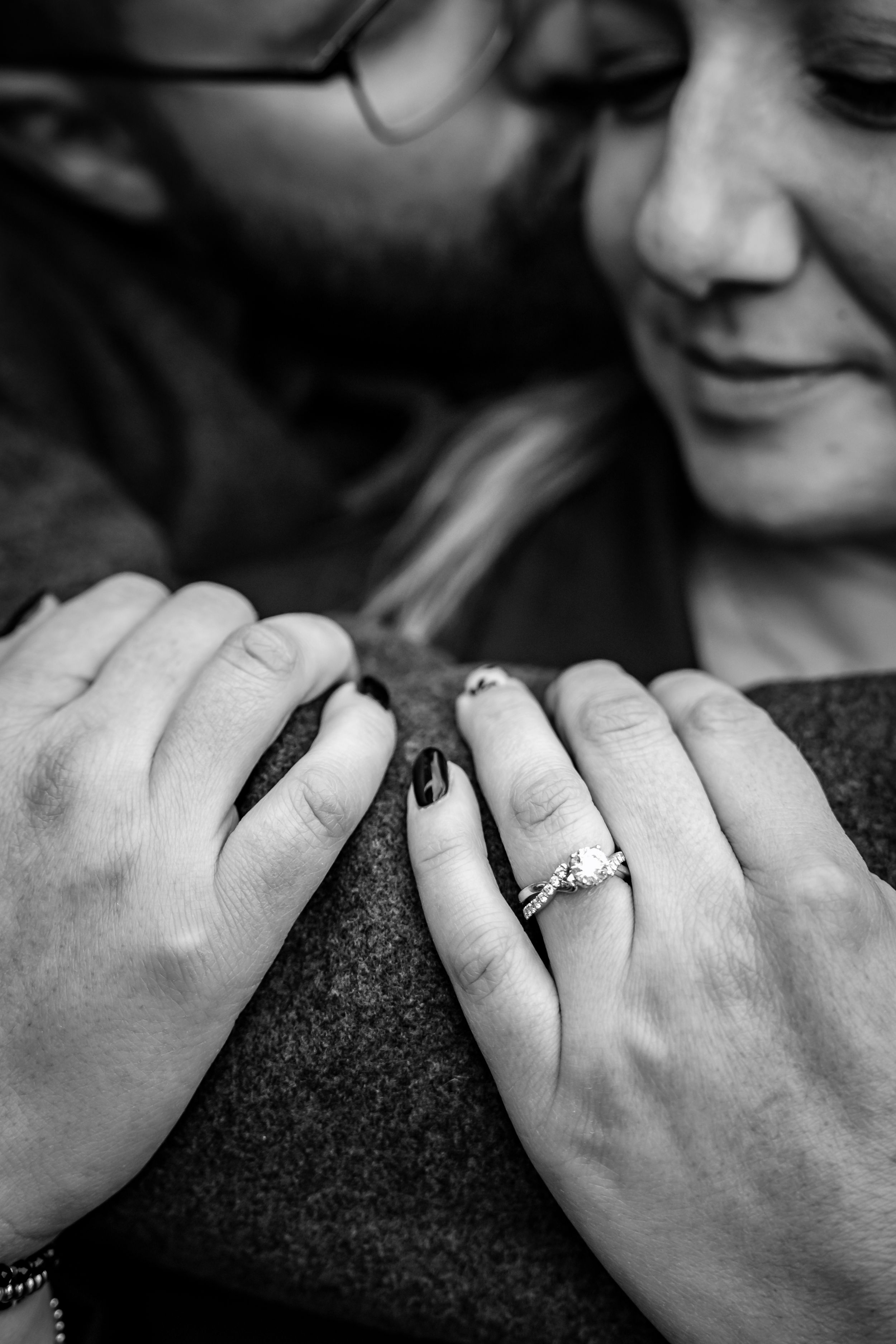 Close-up shots of hands displaying engagement rings with a dark textured background.