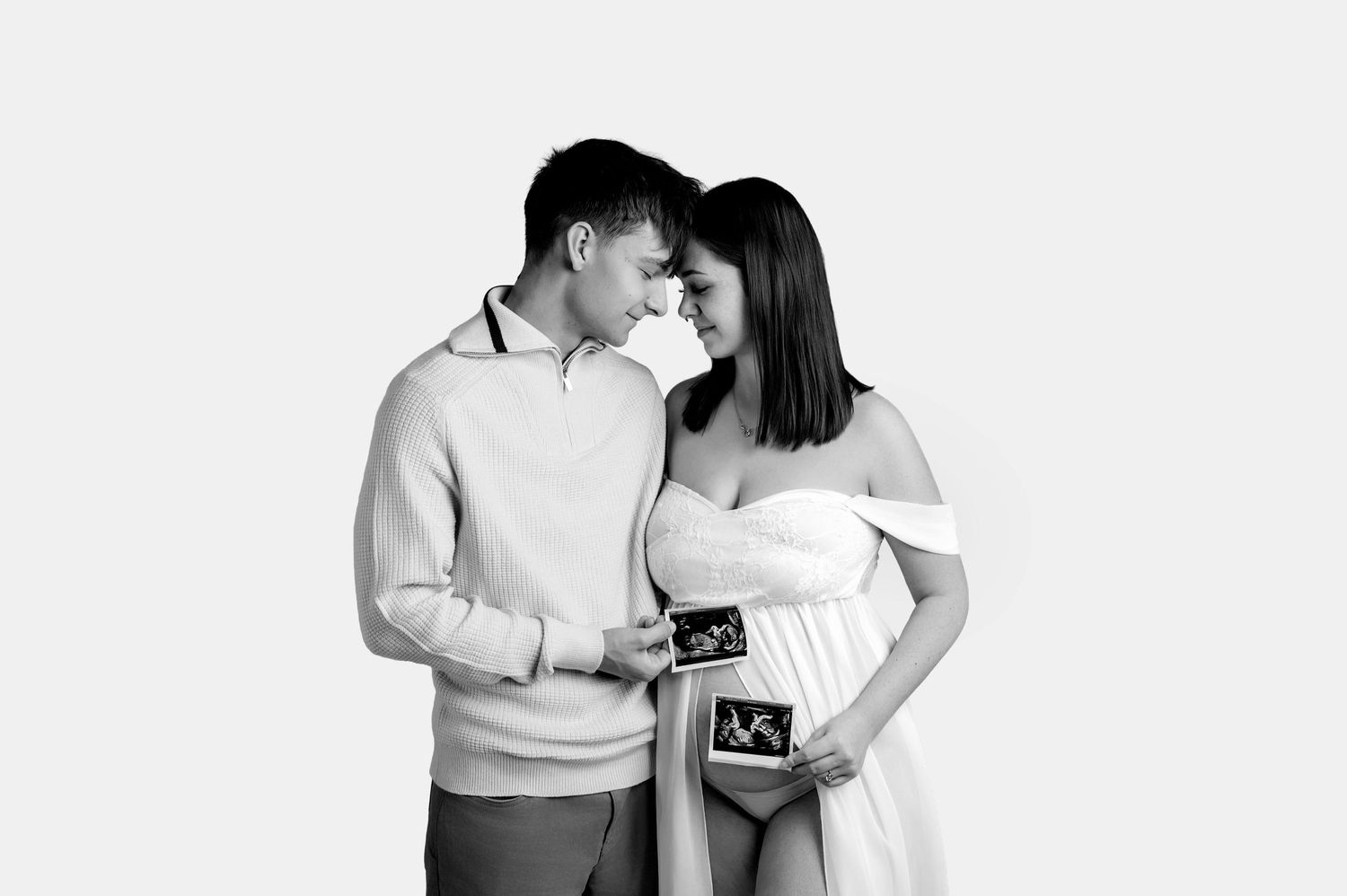 Black and white photo series showing a couple holding and looking at ultrasound photos with joy.