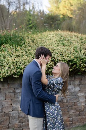 Romantic photo sequence against a stone wall with blooming bushes in the background.