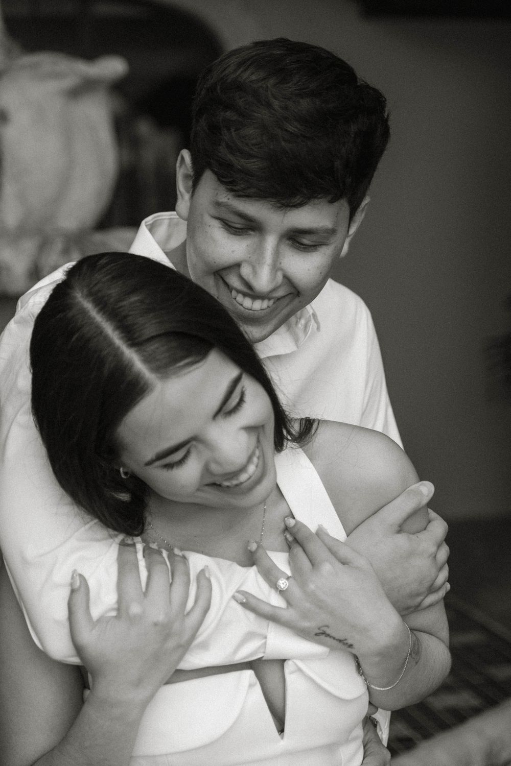 A joyful embrace captured in black and white with natural lighting.