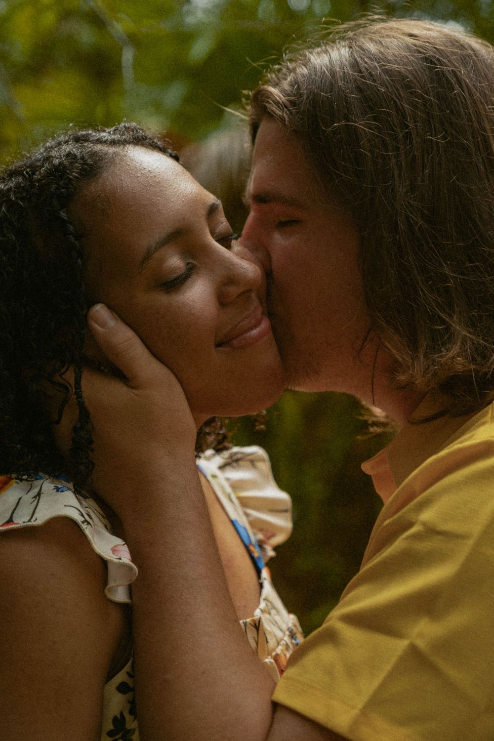 An intimate couple's portrait shows a tender moment in golden sunlight.