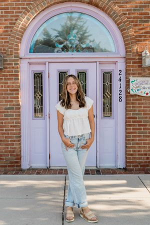 A series of photos showing someone posing in front of pink double doors and brick walls wearing casual summer attire.