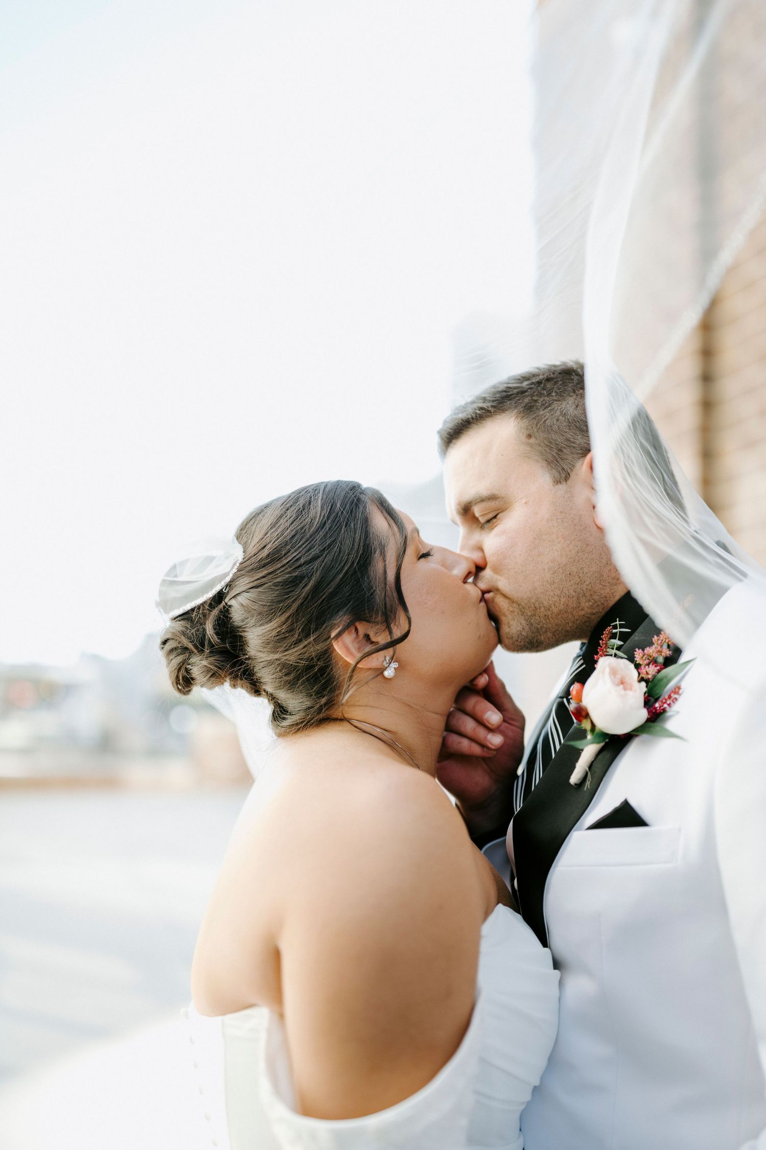 A romantic wedding kiss sequence showing four progressive shots of a couple under a white veil.