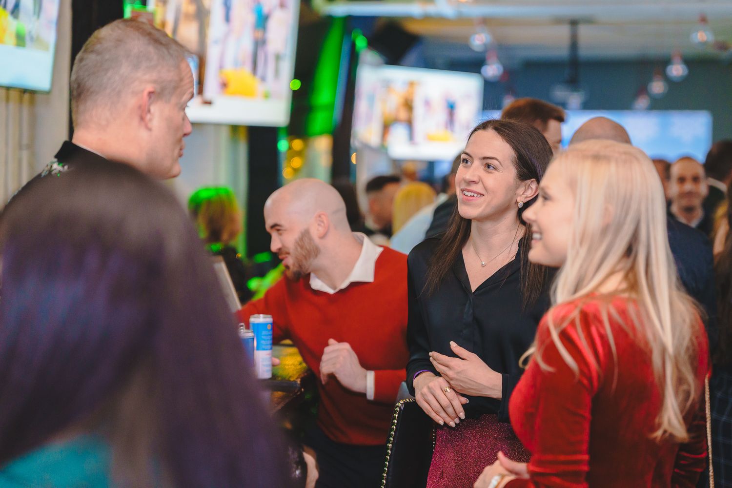 People engaged in conversation at a casual indoor networking event.