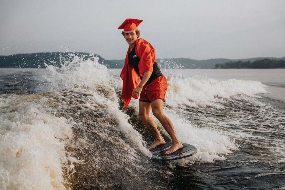 Action sequence of wake surfing on a lake with splashing waves and water spray.