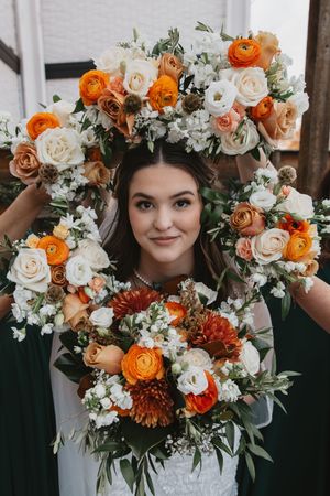 Beautiful bridal bouquet featuring orange and white roses with delicate greenery.
