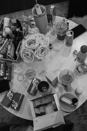 A series of black and white photos showing table settings with roses, drinks, and decorative elements at an event.