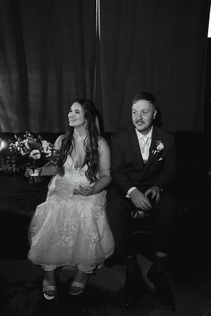 Black and white portrait of newlyweds sitting together in an intimate moment.