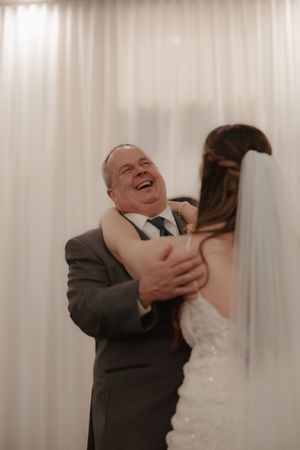 Indoor wedding photos showing playful and candid moments between the couple against white curtain backdrop.