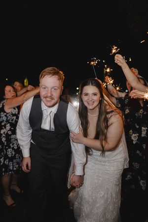 Newlyweds dance and celebrate with sparklers during their wedding reception.