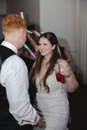 Wedding reception dance party with bride in white dress enjoying festivities.