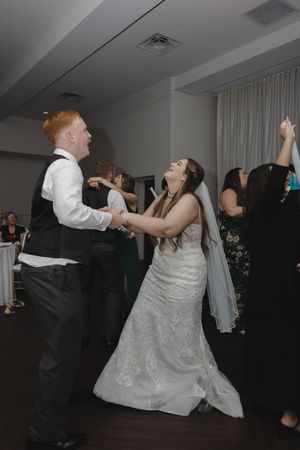 Energetic dance moves on display during wedding reception party.