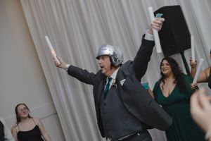 Wedding reception celebration with guests and wedding party dancing and cheering enthusiastically.